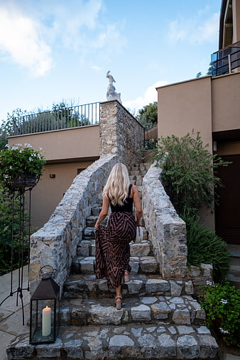 Woman in Patterned Skirt Walking Up Stone Stairs Outdoors