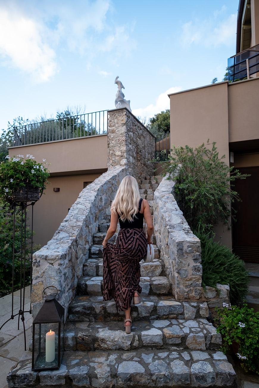 Woman in Patterned Skirt Walking Up Stone Stairs Outdoors