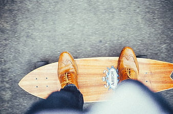 Top View of Brown Leather Shoes on Wooden Longboard