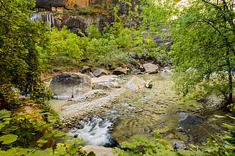 Serene River Flowing Through Rocky Canyon with Lush Greenery