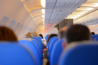 Interior of Airplane Cabin with Blue Seats and Passengers