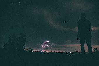 Silhouette of Man Standing Under Starry Night Sky