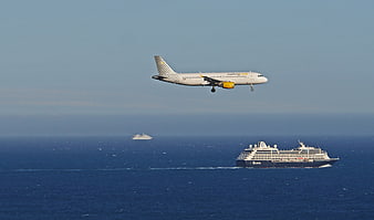 Vueling airplane landing over cruise ship in Mediterranean sea