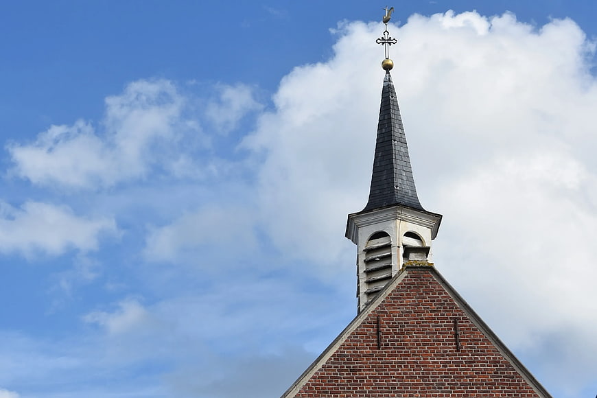Church Steeple with Weather Vane Against Blue Sky