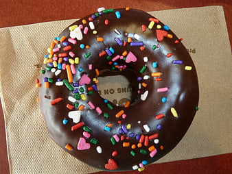 Chocolate Donut with Colorful Sprinkles on Napkin
