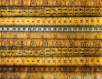 Vintage wooden rulers and measuring tapes stacked horizontally