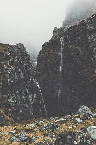 Misty Mountain Waterfall Cascading Down Rocky Cliff