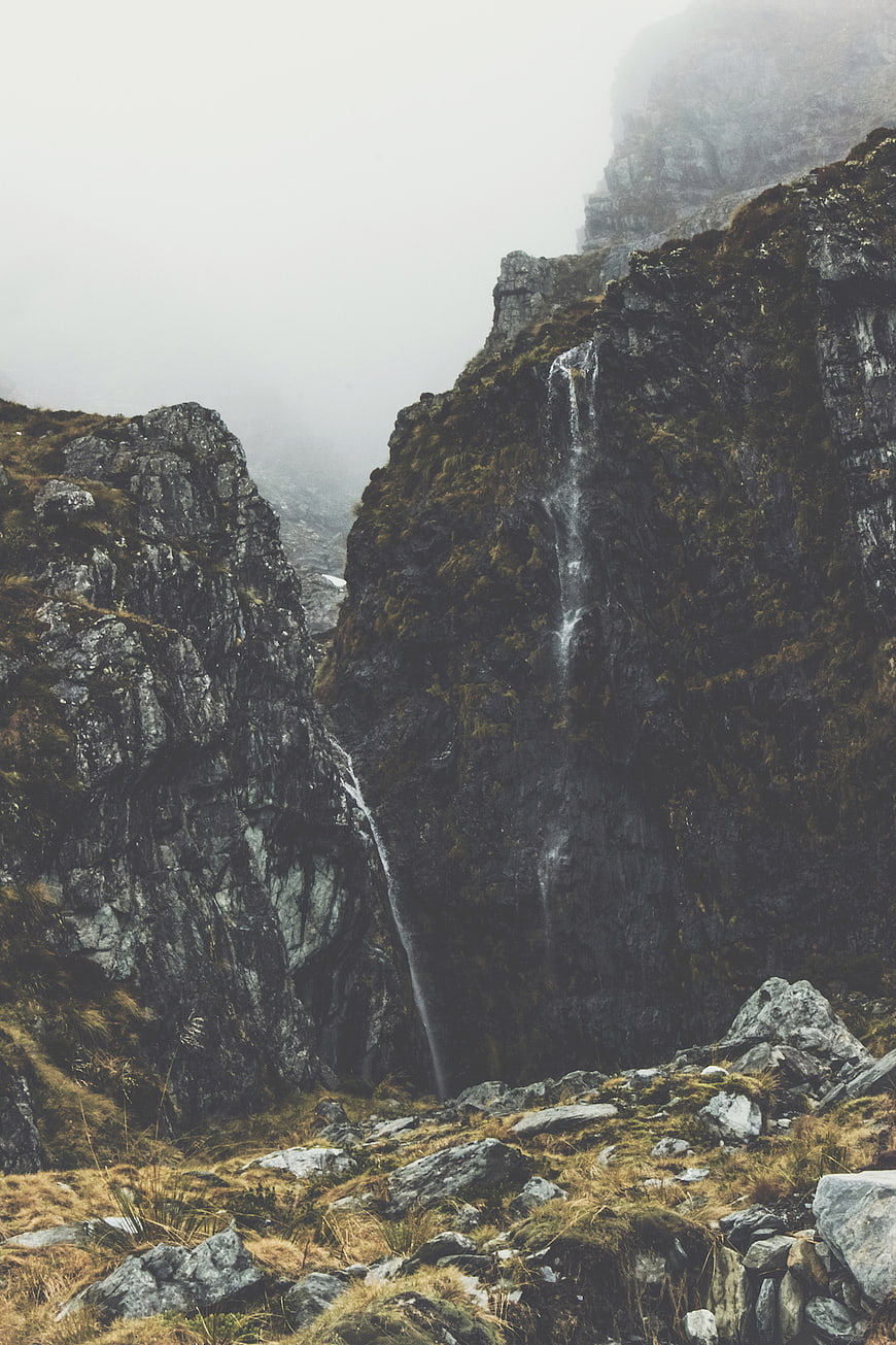 Misty Mountain Waterfall Cascading Down Rocky Cliff