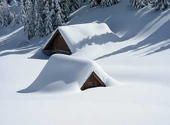 Snow-covered wooden cabins in winter mountain landscape