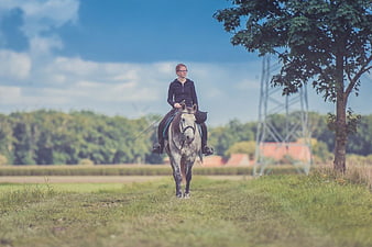 Woman Riding Grey Horse in Green Field