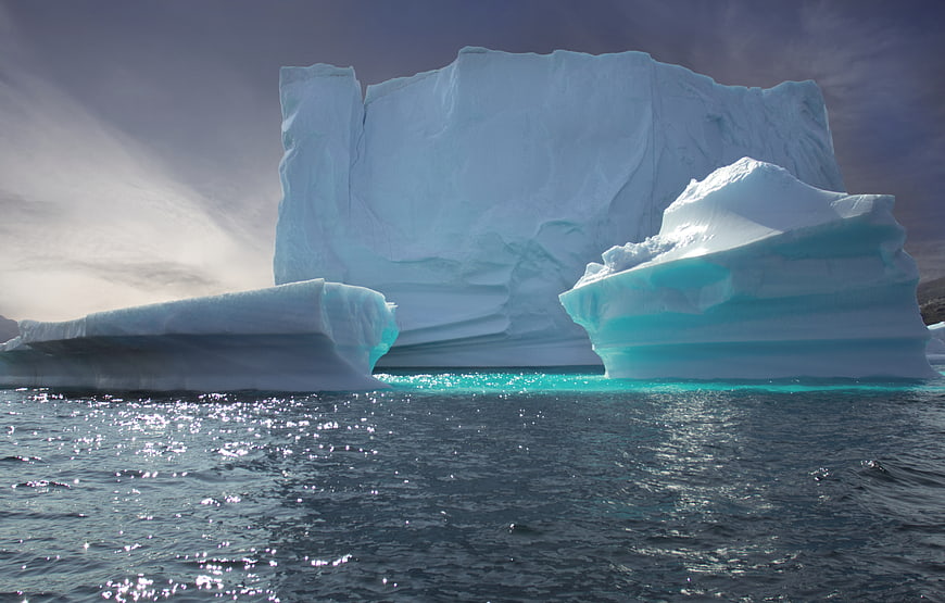 Massive Blue Iceberg Floating in Ocean Water