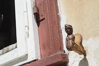 Close-up of ornate wooden window latch on old building
