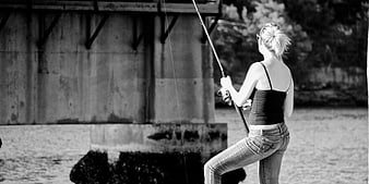 Woman Fishing Under Concrete Bridge in Black and White