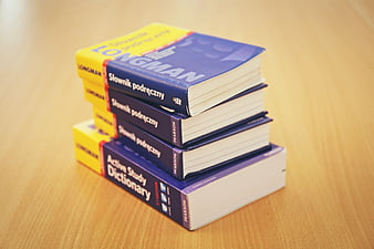 Stack of English-Polish Dictionaries on Wooden Desk