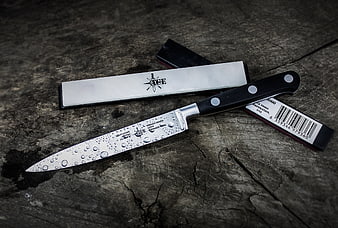 Kitchen knife and sharpening steel on rustic wood