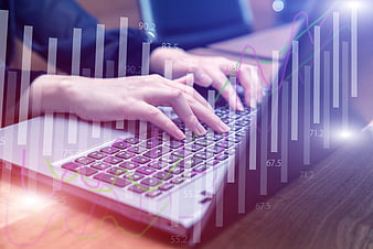Hands typing on laptop with financial data overlay