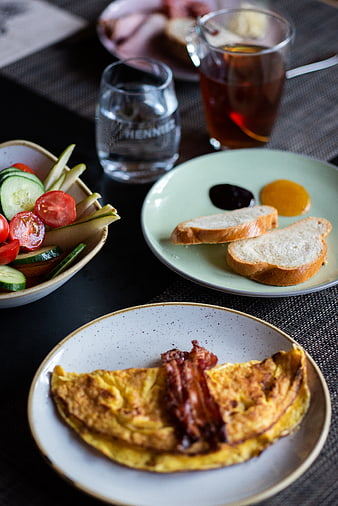 Delicious breakfast omelet with bacon, toast, and fresh vegetables