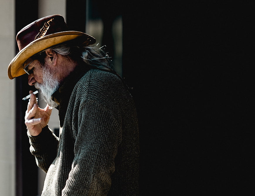Senior man with beard smoking cigarette in profile