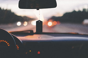 Car Air Freshener Hanging from Rearview Mirror at Dusk