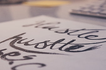 Close-up of handwritten hustle calligraphy on paper
