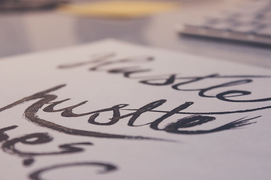 Close-up of handwritten hustle calligraphy on paper