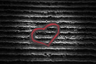 Red heart drawn on textured black and white background