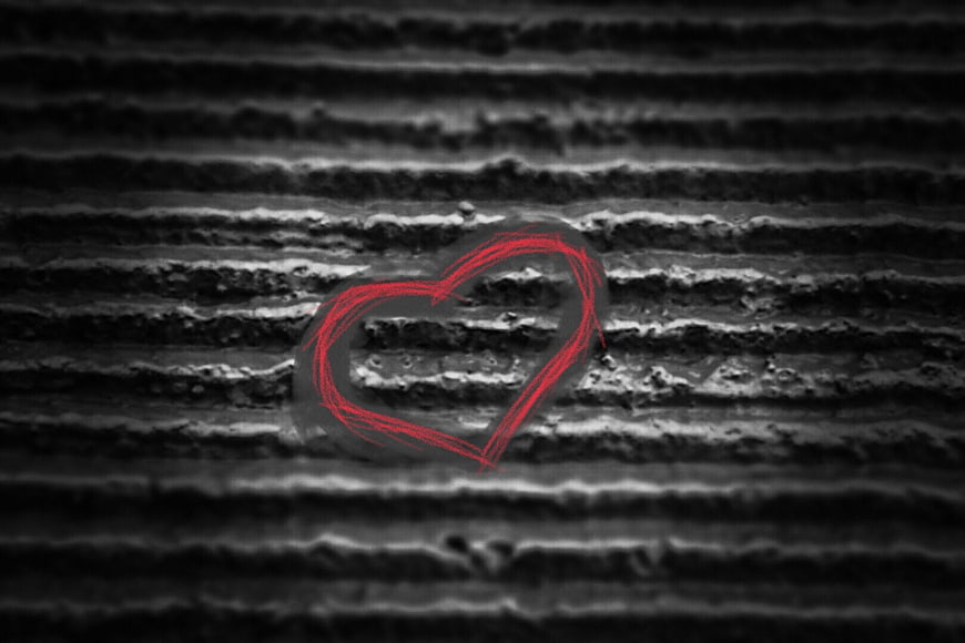 Red heart drawn on textured black and white background