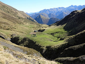 Scenic Mountain Valley with Cabin and Distant Peaks