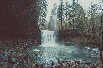 Misty Waterfall in Dark Forest with River