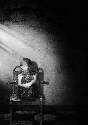 Melancholic Black and White Portrait of a Lonely Child Sitting on a Chair
