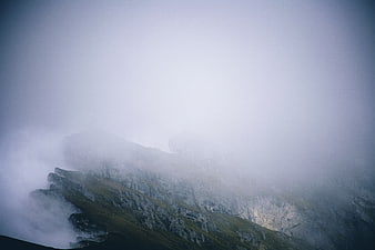 Misty Mountain Ridge with Fog and Green Grass