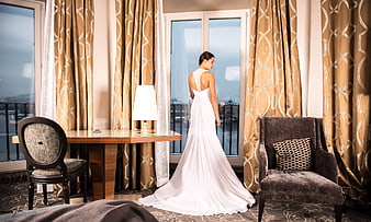 Bride in White Wedding Dress Looking Out Hotel Window