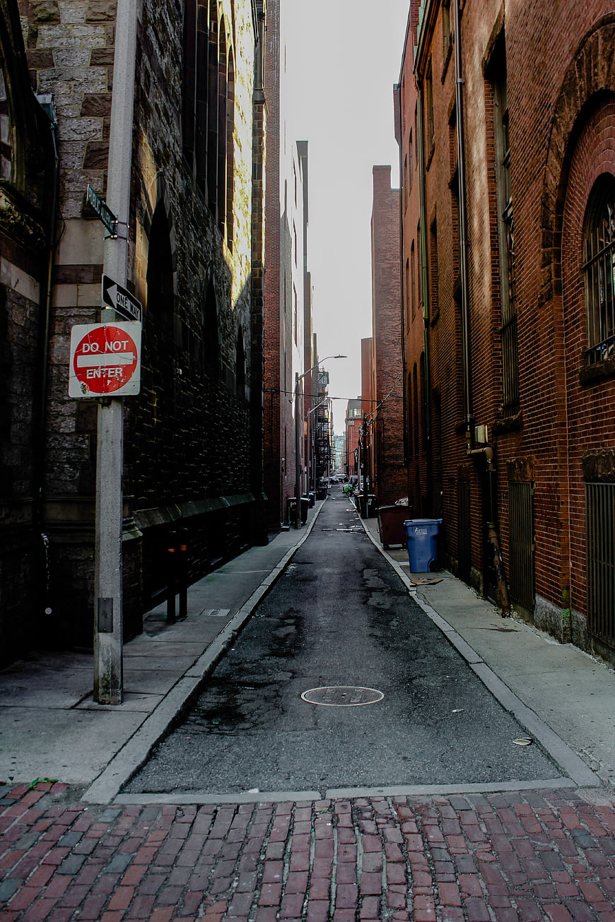 Narrow Urban Alleyway with Brick Buildings and Do Not Enter Sign