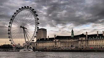 London Eye Ferris Wheel and Westminster Architecture Under Dramatic Clouds