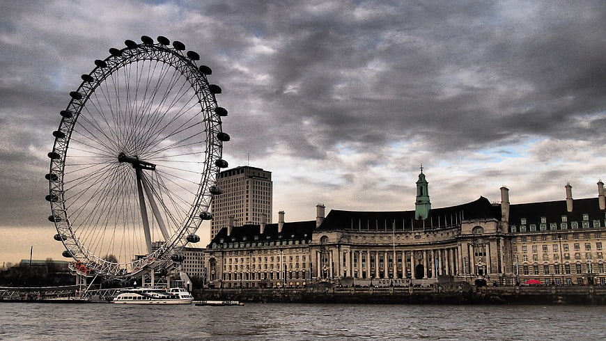London Eye Ferris Wheel and Westminster Architecture Under Dramatic Clouds