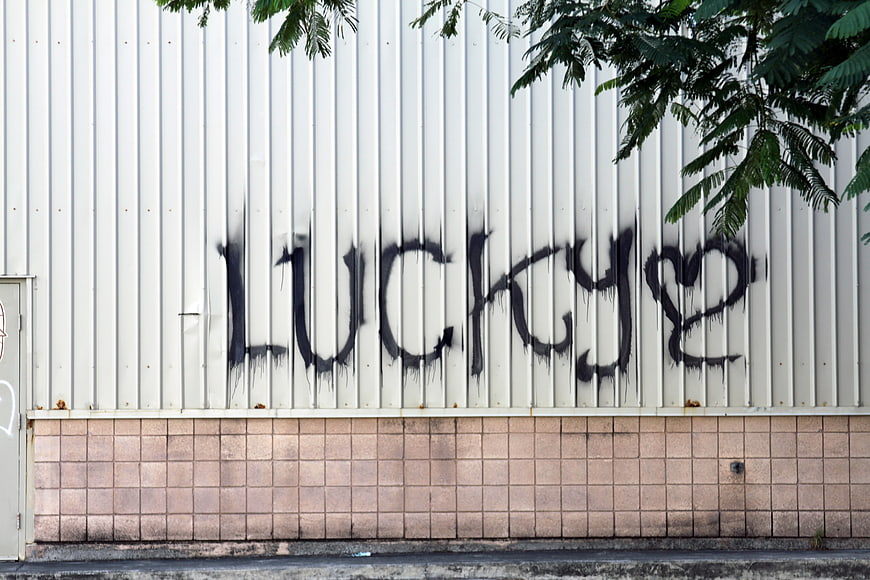 Lucky Graffiti on White Corrugated Metal Wall