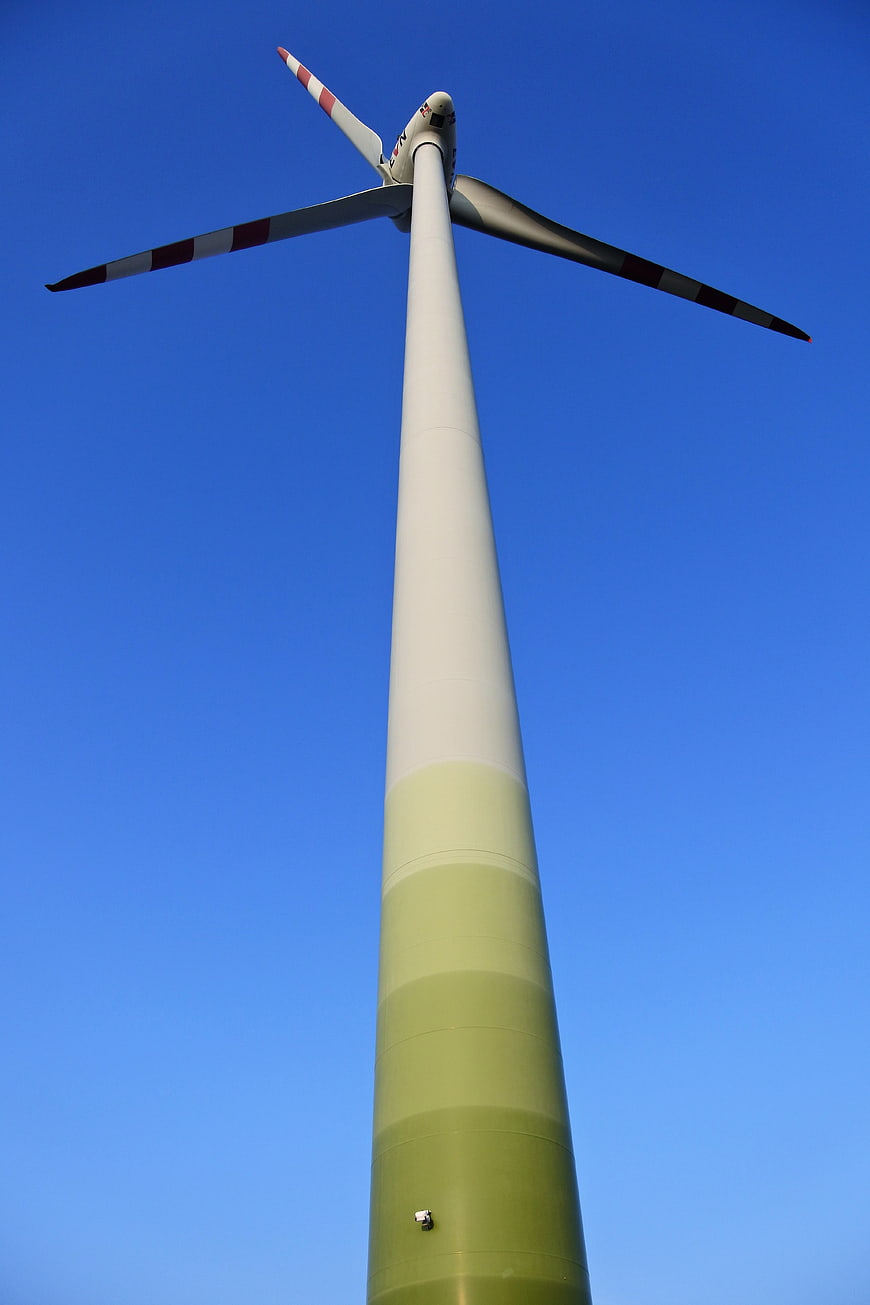 Low angle view of wind turbine against blue sky