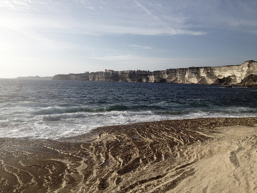 Sandy Beach with White Cliffs and Ocean Waves