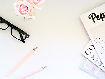 Minimalist flat lay with pink roses, glasses, and magazines