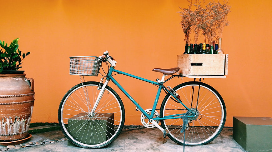 Teal Bicycle with Wooden Crate on Orange Wall