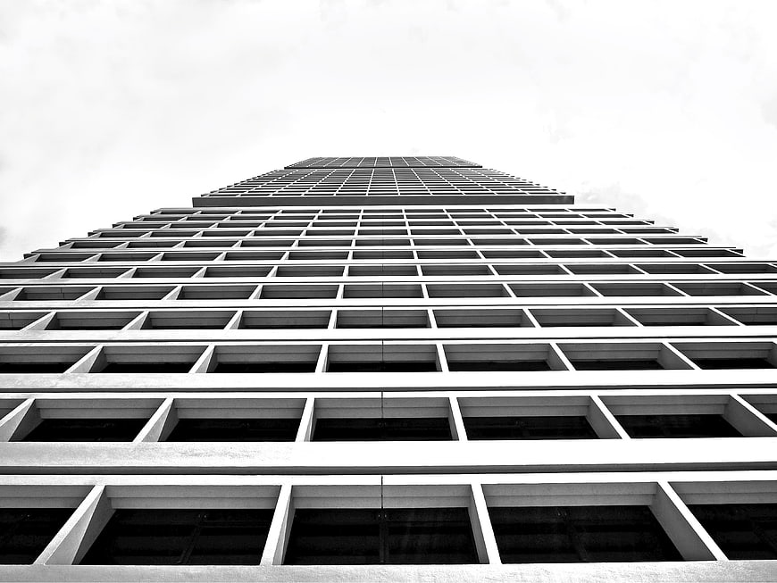 Low angle black and white skyscraper facade with grid pattern