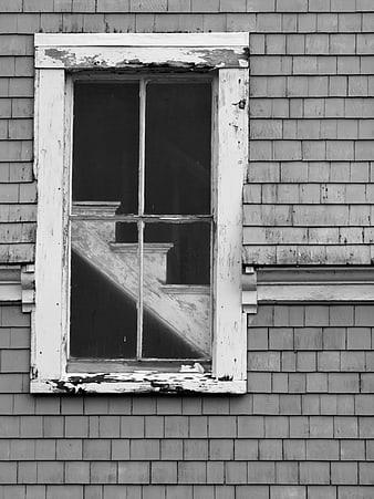 Black and white weathered window on old shingled house exterior