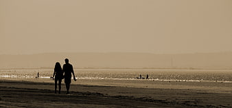 Silhouette of Couple Walking on Beach at Sunset