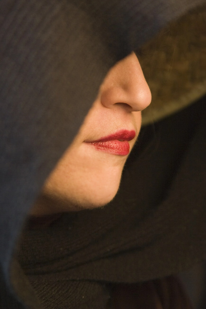 Close-up of Woman in Dark Hood with Red Lipstick
