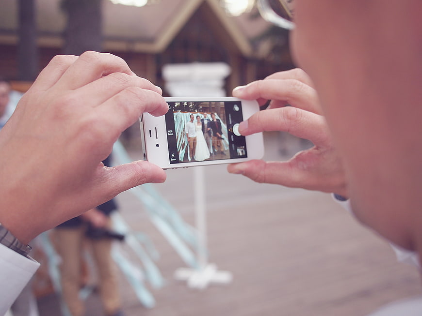 Man taking wedding photo with smartphone camera