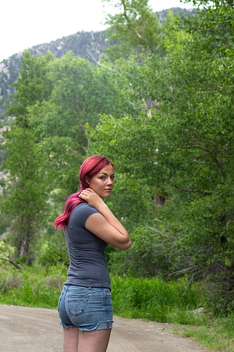 Woman with Pink Hair Standing on Dirt Road in Nature
