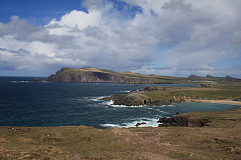 Scenic coastal landscape with cliffs, ocean, and dramatic clouds