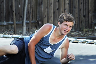 Teenage boy relaxing on trampoline outdoors