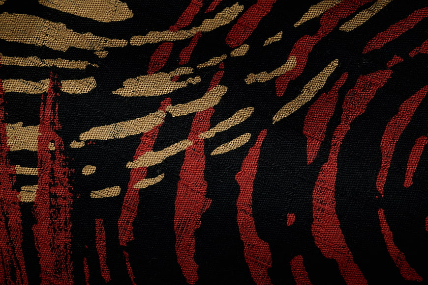 Abstract Red and Gold Brushstroke Pattern on Black Fabric