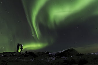 Aurora Borealis Over Rocky Landscape With Silhouetted People